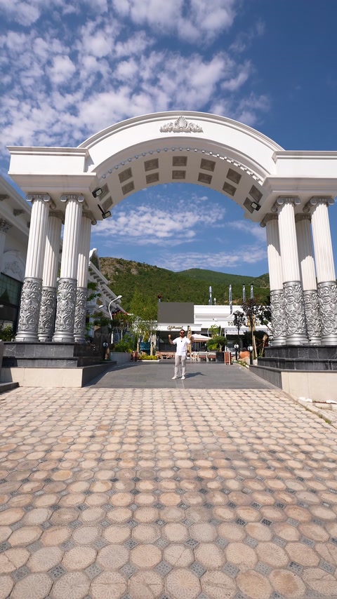 Grand exterior entrance combines columns, an arch, and ornamental facade details.