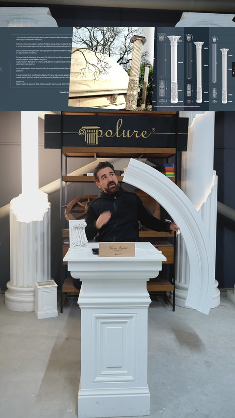 Designer presents a large curved moulding sample beside decorative columns.
