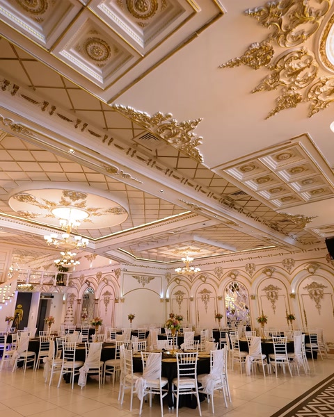 Ampia vista della sala da ballo con modanature di soffitto a griglia e finiture dorate