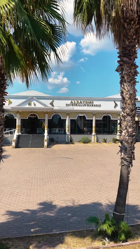 Exterior facade of Albatros wedding hall with columns and palm trees