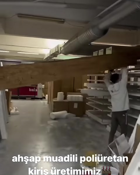 Una trave decorativa di colore scuro viene spostata all’interno del laboratorio