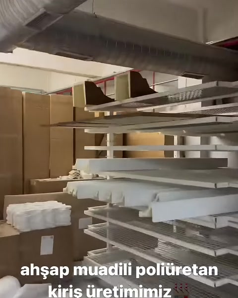 Profili decorativi bianchi sono impilati ordinatamente sugli scaffali del laboratorio