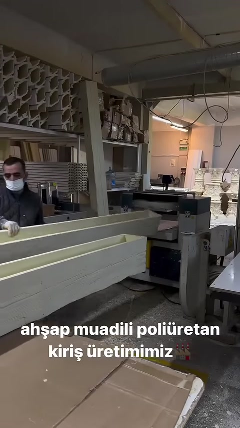 Il corpo di una lunga trave in poliuretano viene guidato verso la macchina in laboratorio