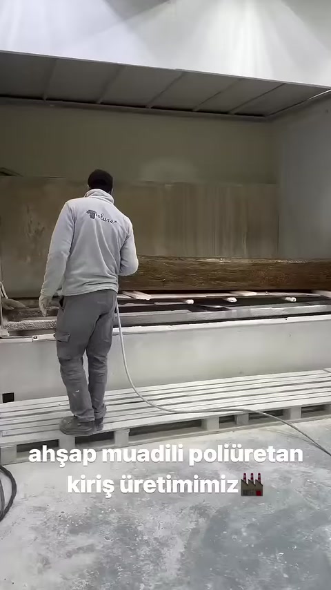 Una trave effetto legno marrone viene esaminata sul banco da lavoro