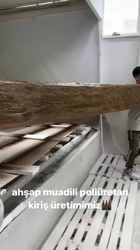 Il corpo lungo di una trave in poliuretano verniciata viene esposto sul banco da lavoro