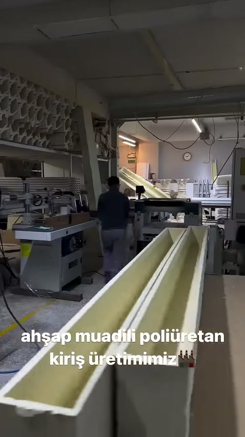 L'operaio controlla le travi di colore chiaro sulla linea della macchina.