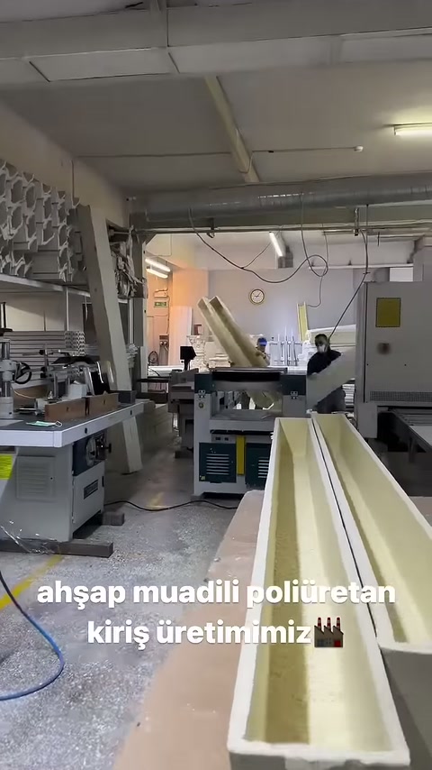 L'operaio guida il profilo della trave lunga dall'estremità opposta del banco.