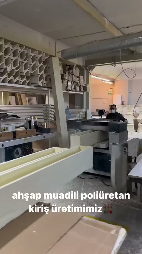 I profili della trave scanalati si estendono dal pavimento del laboratorio verso la macchina.