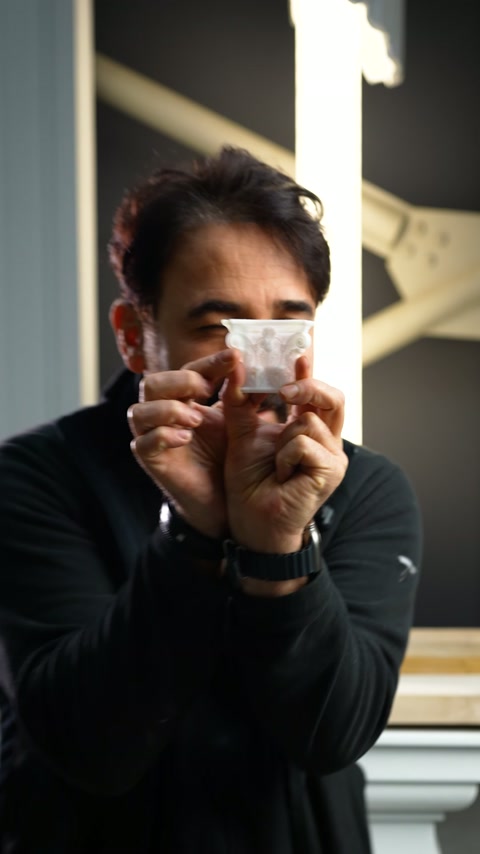 Un maestro artigiano mostra il piccolo pezzo di capitello davanti alla fotocamera