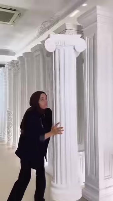 Il presentatore mostra il capitello decorativo e la struttura del fusto di una colonna scanalata.