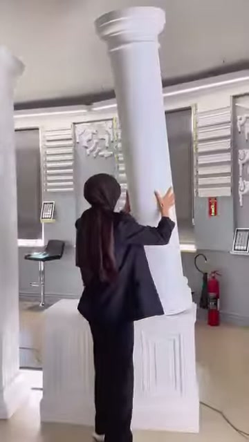 Una colonna diritta su base panellata quadrata viene esaminata nell'ambiente showroom.