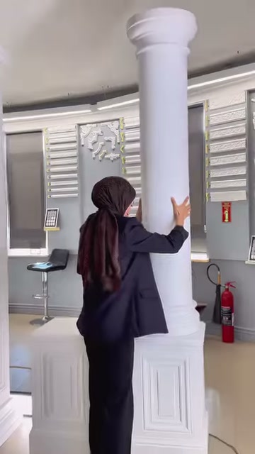L'unione tra il fusto e la base rotonda della colonna bianca rotonda viene presentata da vicino.