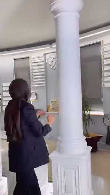 Una colonna decorativa con fusto liscio viene esposta verticalmente con la sua base quadrata.
