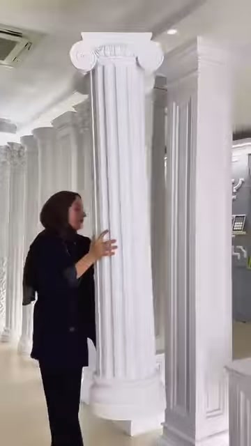 Il presentatore indica con la mano i canali verticali della colonna scanalata lunga.