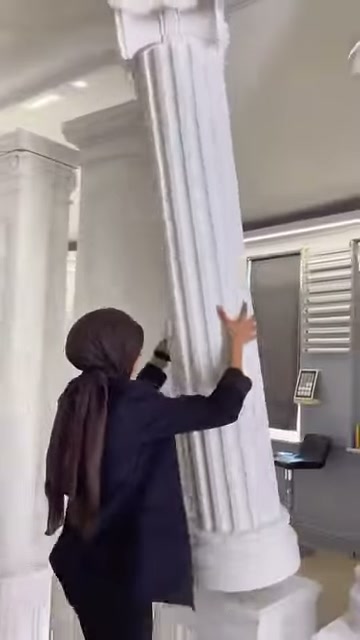 Il presentatore tocca i profondi e paralleli canali nel fusto della colonna.