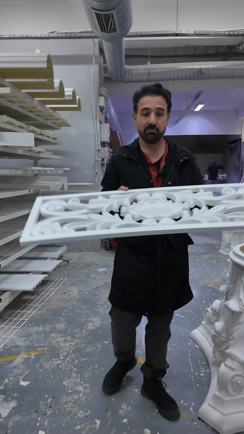 Pannello decorativo traforato in poliuretano tenuto accanto a un capitello per colonna