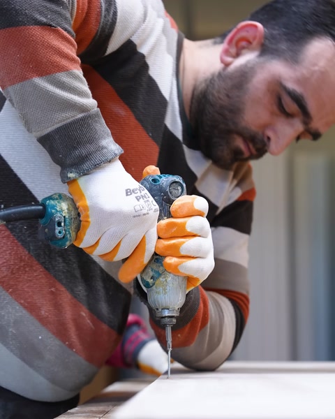 Drilling screws into the wooden frame of the table structure