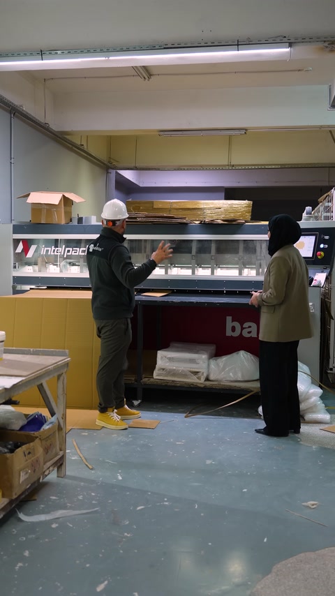 Le fasi produttive vengono illustrate davanti a un macchinario industriale