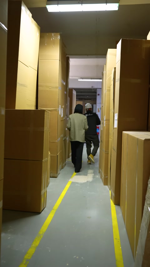 Visita della fabbrica nel corridoio del magazzino con prodotti confezionati disposti in fila