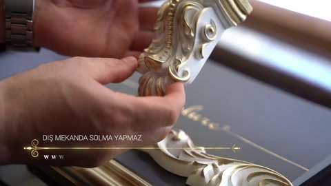 Boyalı kıvrımlı dekor parçasının parlak yüzey ayrıntıları yakından görülüyor.