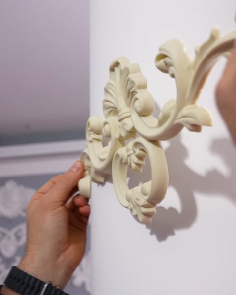 Il primo piano rivela i dettagli degli applique floreali ornati su una parete