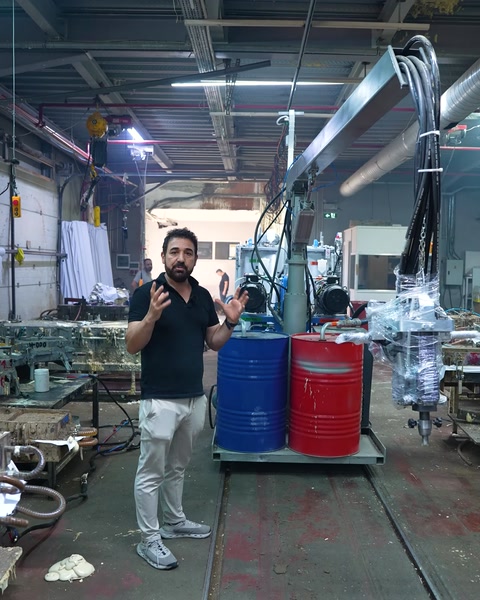 Uno specialista spiega l'attrezzatura di fabbricazione in poliuretano sul pavimento della fabbrica