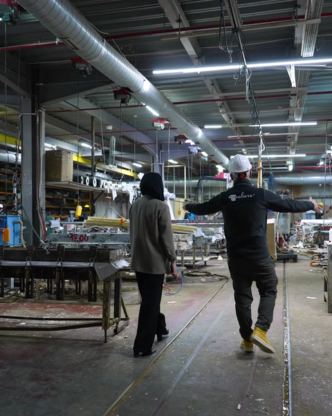 Il team percorre un'area di produzione industriale con macchinari