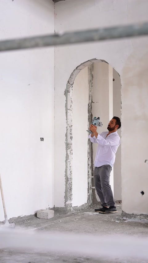 Worker installs a decorative arch surround on an interior wall