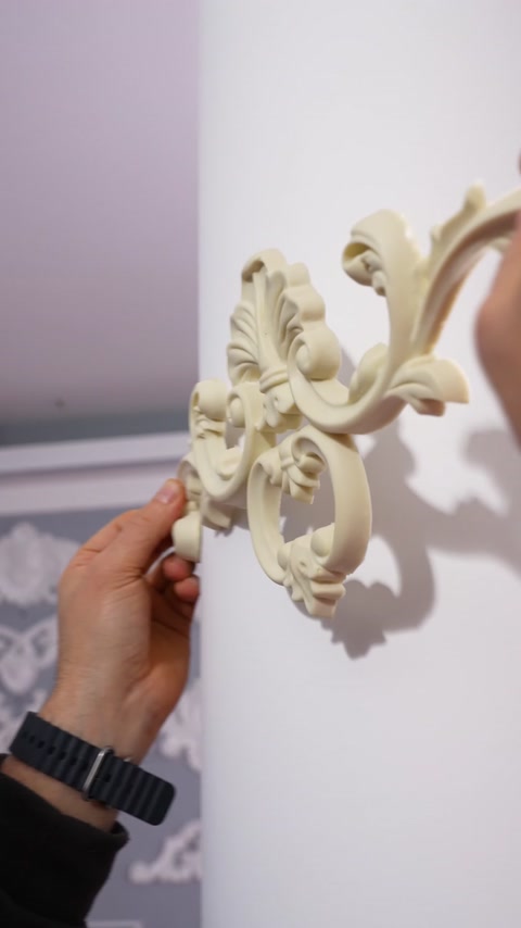 Close-up reveals ornate floral applique detailing on a wall