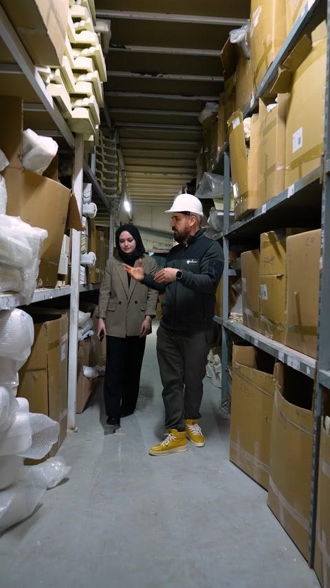 Team members inspect packaged architectural decoration products in storage