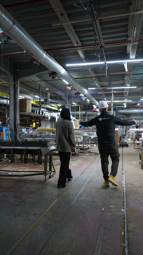 Team walks through an industrial production area with machinery