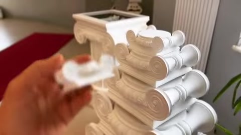 Un piccolo elemento decorativo viene posizionato su un capitello con volute