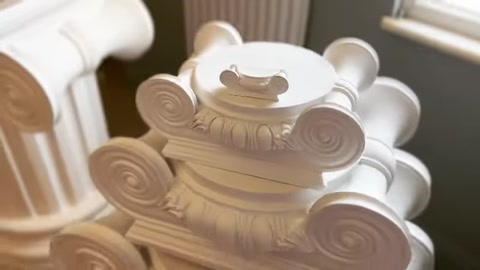 Il dettaglio superiore completato di un capitello con volute e decorazioni fogliari
