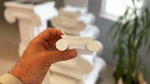 The curved edges of a small profile cross-section held in hand are examined up close.