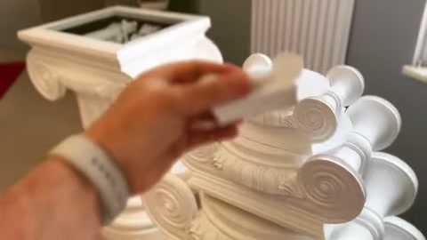 A white upper ornament is moved toward the circular center of a capital.