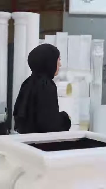 Il presentatore inizia a camminare verso il modello di colonna più corta nell'area espositiva