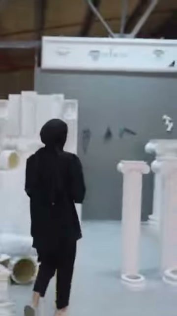 Il presentatore si avvicina ai modelli di colonna indipendenti per esaminarli