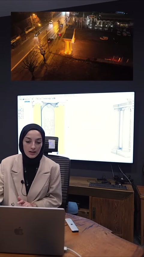 Il progettista continua a illustrare gli schizzi di colonne decorative accanto al computer.