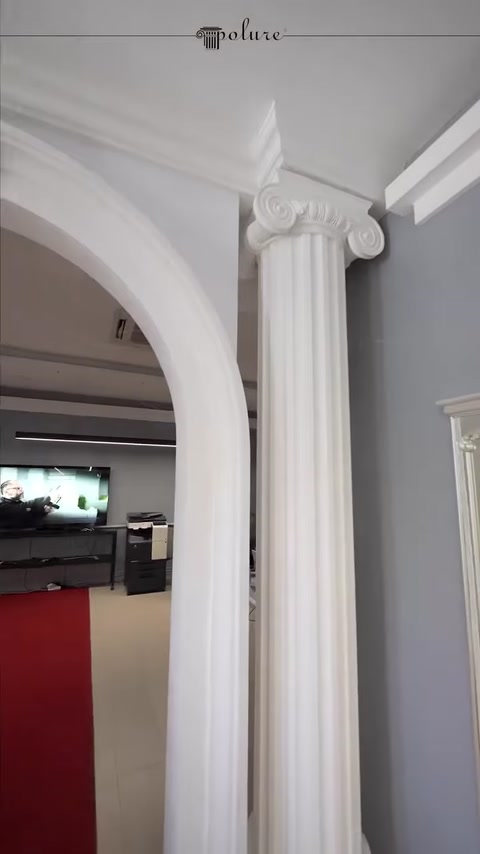 The combination of a classical column capital, arch, and ceiling mouldings
