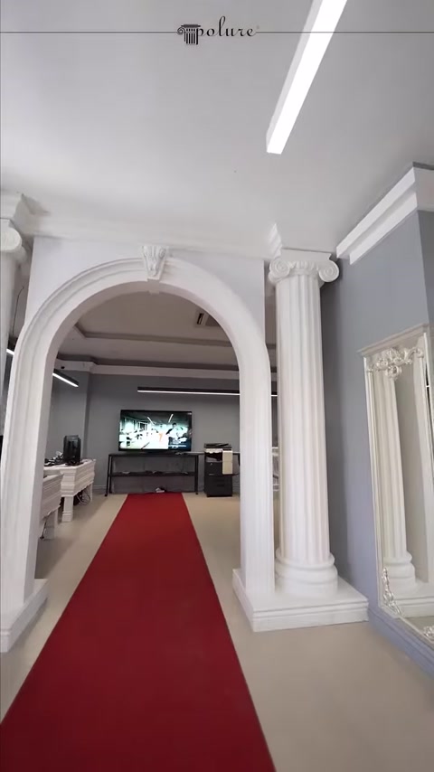 A showroom passage with an arch surrounded by two decorative columns