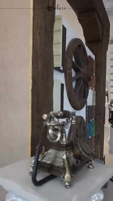Dettagli di decorazioni metalliche e ruota in legno visibili all'ingresso della showroom