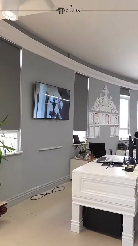 Cornici decorative su parete grigia della showroom con tavolo di lavoro