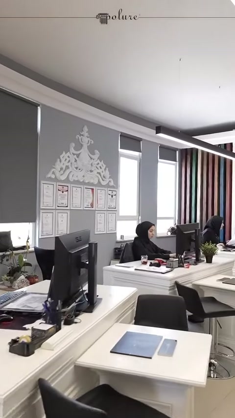 Decorazioni murali e tavoli bianchi nella sezione ufficio della showroom