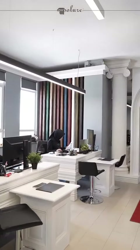 Colonne bianche, mobili per ufficio e illuminazione a soffitto insieme