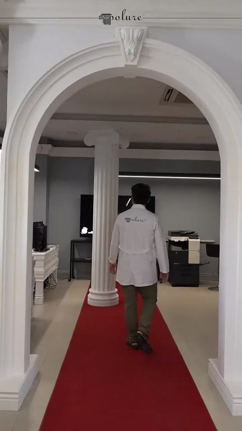 Colonna scanalata sotto l'arco bianco che marca il passaggio della showroom