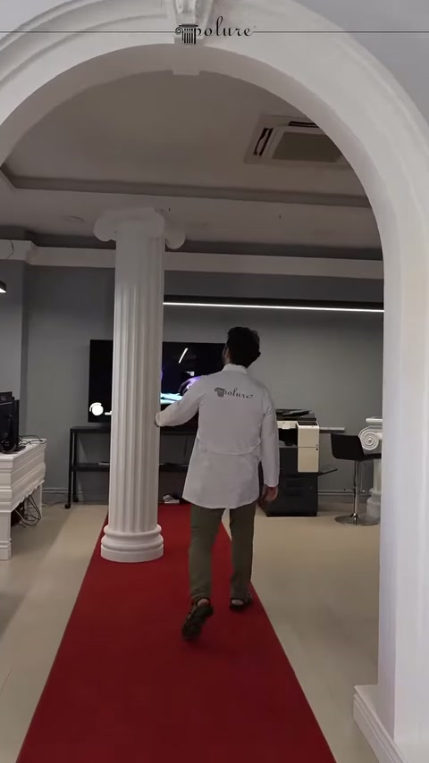Arco e colonna centrale esaminati insieme nel corridoio con tappeto rosso
