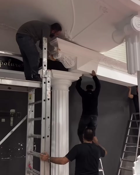 Ekip, sütunların üzerine geniş dekoratif üst kirişi yerleştiriyor