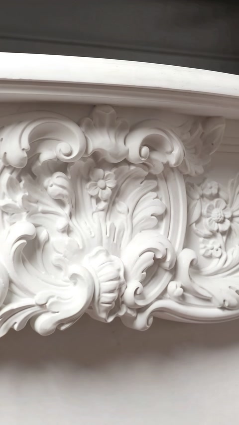 Rococo floral cartouche and acanthus scrollwork decorate the central frieze