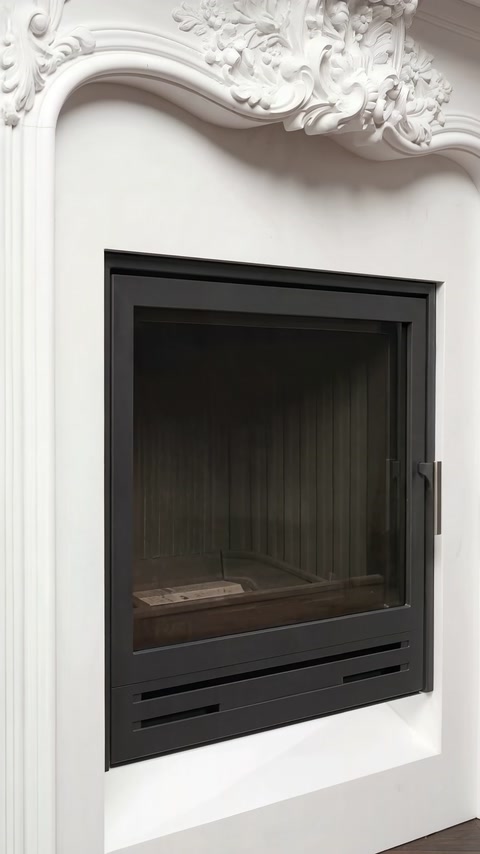 Black fireplace insert framed by curved white decorative mouldings