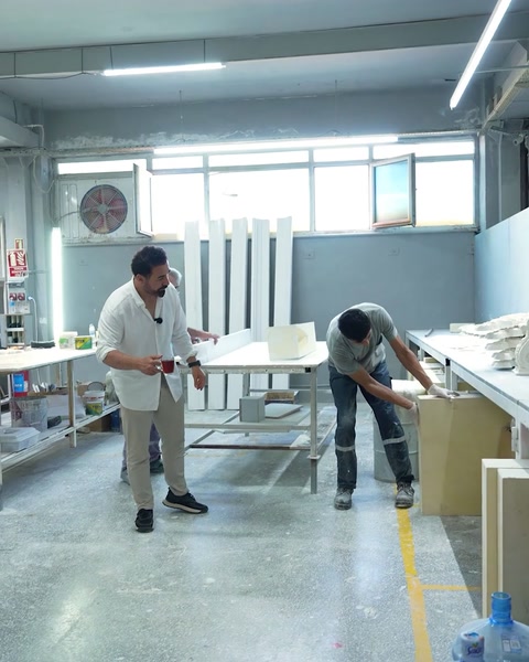 I lavoratori preparano un grande pannello all'interno dell'officina di produzione di poliuretano